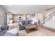 Open-concept living area connecting the kitchen, dining, and living spaces, featuring modern furnishings and wood-look flooring at 6164 Brighton Dr, Whitestown, IN 46075