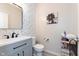 Charming powder room with modern vanity, decorative wallpaper, and stylish floral artwork at 6164 Brighton Dr, Whitestown, IN 46075
