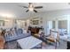 Open-concept living room with modern decor, neutral colors, a ceiling fan, and seamless flow to the dining area at 6195 Woodmill Dr, Fishers, IN 46038