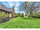 Backyard showcasing manicured lawn, mature trees, and the home's brick exterior at 621 Thorne Dr, Brownsburg, IN 46112