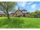 Backyard featuring a brick house, a spacious lawn, and landscaping at 621 Thorne Dr, Brownsburg, IN 46112