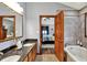 Bathroom with granite counters, travertine tub, and doorway to the bedroom at 621 Thorne Dr, Brownsburg, IN 46112