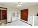 Comfortable bedroom featuring a ceiling fan, wood closet doors, white dressers and a decorative mirror at 621 Thorne Dr, Brownsburg, IN 46112