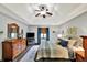 Comfortable bedroom with natural light, wood dresser, hardwood flooring, and a TV at 621 Thorne Dr, Brownsburg, IN 46112