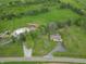 Wide aerial shot showcases a well-manicured property with mature trees, a house, and a long driveway at 6212 Rocklane Rd, Greenwood, IN 46143