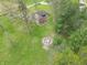 An aerial shot features a brick home with a firepit area in the backyard surrounded by mature trees at 6212 Rocklane Rd, Greenwood, IN 46143