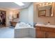 Bright bathroom featuring a tiled whirlpool tub, double vanity with marble countertops, and a walk-in closet at 6212 Rocklane Rd, Greenwood, IN 46143