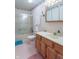 Well-lit bathroom with a vanity, tub/shower combo, toilet, and medicine cabinet with floral wallpaper at 6212 Rocklane Rd, Greenwood, IN 46143