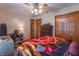 Charming bedroom with a wooden dresser, closet, and a decorative firetruck themed blanket on the bed at 6212 Rocklane Rd, Greenwood, IN 46143