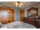 Spacious bedroom featuring wooden closet doors, ceiling fan, and dresser with a large mirror at 6212 Rocklane Rd, Greenwood, IN 46143