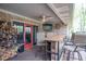 Cozy, covered deck space with a mounted TV, a wood pile and counter seating perfect for enjoying outdoor living at 6212 Rocklane Rd, Greenwood, IN 46143