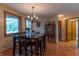 A dining room features wood-framed windows, a modern chandelier, and a table set for an elegant meal at 6212 Rocklane Rd, Greenwood, IN 46143