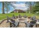 Outdoor stone fire pit encircled by Adirondack chairs, perfect for gatherings and enjoying the serene landscape at 6212 Rocklane Rd, Greenwood, IN 46143