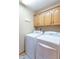Convenient laundry room with overhead wooden cabinets and modern washer and dryer units at 6212 Rocklane Rd, Greenwood, IN 46143