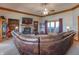 Cozy living room with brick fireplace, ceiling fan, a large leather couch, and access to the outdoors at 6212 Rocklane Rd, Greenwood, IN 46143