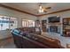 Spacious living room features a stone fireplace, plush seating, a ceiling fan, and wooden trim at 6212 Rocklane Rd, Greenwood, IN 46143
