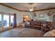 Inviting living room with french doors, ceiling fan, and a large leather couch at 6212 Rocklane Rd, Greenwood, IN 46143