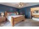 Main bedroom with carpet, blue walls, a wooden bed frame, and a view into the ensuite bathroom at 6212 Rocklane Rd, Greenwood, IN 46143