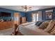 A well-lit main bedroom showcases dark blue walls, a wooden bed frame, and warm, cozy furniture at 6212 Rocklane Rd, Greenwood, IN 46143