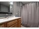Bathroom with a white sink, wood cabinets, and a shower with gray shower curtain at 625 Maple St, Columbus, IN 47201