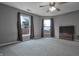 Spacious bedroom featuring a ceiling fan, plush neutral carpeting and two windows with dark curtains at 625 Maple St, Columbus, IN 47201