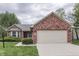 Charming single-story home featuring brick accents, a well-manicured lawn, and an attached two-car garage at 6337 Whitaker Farms Dr, Indianapolis, IN 46237