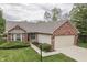 Charming single-story home with brick accents, a well-manicured lawn, and an attached two-car garage at 6337 Whitaker Farms Dr, Indianapolis, IN 46237