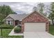 Charming single-story home featuring brick accents, a well-manicured lawn, and an attached two-car garage at 6337 Whitaker Farms Dr, Indianapolis, IN 46237