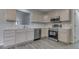 Well-lit kitchen with stainless steel appliances, neutral cabinets, and gray wood flooring at 6337 Whitaker Farms Dr, Indianapolis, IN 46237