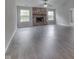 Spacious living room with fireplace, gray walls, light gray flooring, and two large windows at 6337 Whitaker Farms Dr, Indianapolis, IN 46237