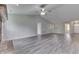 Spacious living room featuring a ceiling fan, gray walls, and lovely gray wood flooring at 6337 Whitaker Farms Dr, Indianapolis, IN 46237
