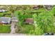 Aerial view of a property with a well-maintained lawn, mature trees, and a charming home with a red roof at 6837 Doris Dr, Indianapolis, IN 46214