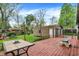 View of backyard with a wooden deck, picnic table and detached one car garage at 6837 Doris Dr, Indianapolis, IN 46214