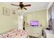 Cozy bedroom features natural light, ceiling fan, and a dresser with a TV at 6837 Doris Dr, Indianapolis, IN 46214