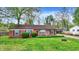 Well-maintained brick home with a green lawn, tidy landscaping, and a bright red front door adding curb appeal at 6837 Doris Dr, Indianapolis, IN 46214