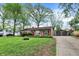 Charming brick home with a detached garage and lengthy driveway, all surrounded by mature trees at 6837 Doris Dr, Indianapolis, IN 46214