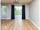 Bright interior with wood floors, modern lighting, and view of backyard through sliding glass door at 7108 Burlat Ln, Noblesville, IN 46062