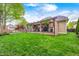 Manicured backyard featuring a covered patio, outdoor fireplace, and lush green lawn at 7653 Carriage House Way, Zionsville, IN 46077