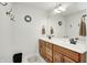 Bright bathroom featuring a double vanity with wood cabinets, a large mirror, and a neutral color scheme at 7653 Carriage House Way, Zionsville, IN 46077