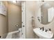 Stylish powder room with a pedestal sink, round mirror, and a separate toilet area at 7653 Carriage House Way, Zionsville, IN 46077