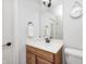 Well-lit bathroom with a wooden vanity, quartz countertop, decorative mirror, and chrome fixtures at 7653 Carriage House Way, Zionsville, IN 46077