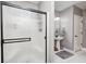 Bathroom featuring a frosted glass shower, pedestal sink, toilet, and white tile flooring at 7653 Carriage House Way, Zionsville, IN 46077