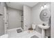 Bathroom with a toilet, sink, a shower behind a clear glass door, and neutral tile at 7653 Carriage House Way, Zionsville, IN 46077