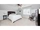 Bright bedroom features a ceiling fan, natural light from the window, a rocking chair, and neutral carpet at 7653 Carriage House Way, Zionsville, IN 46077