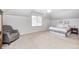 Cozy bedroom features a comfortable chair, ceiling fan and natural light from the window at 7653 Carriage House Way, Zionsville, IN 46077