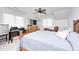 Cozy bedroom with a wooden bed frame, desk, TV, ceiling fan, and natural light at 7653 Carriage House Way, Zionsville, IN 46077