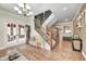 Spacious foyer with hardwood floors, chandelier, stairway with iron spindles, and access to other rooms at 7653 Carriage House Way, Zionsville, IN 46077
