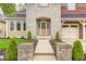 Beautiful stone and brick home with a well-manicured lawn and landscape including charming walkway and front door at 7653 Carriage House Way, Zionsville, IN 46077