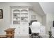 Bright home office featuring custom white built-ins and a comfortable workspace under an angled ceiling at 7653 Carriage House Way, Zionsville, IN 46077