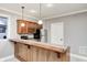 Finished basement kitchenette features a wood bar, stainless steel fridge, upper cabinets, and pendant lighting at 7653 Carriage House Way, Zionsville, IN 46077